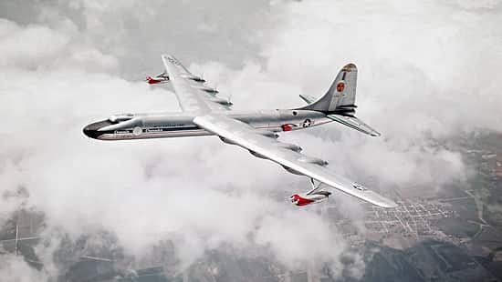 Das Foto zeigt die Convair NB-36H der United States Air Force im Flug über einer geschlossenen Wolkendecke. Das großspannige Propellerflugzeug, eine modifizierte B‑36 für Nuklearforschungszwecke, ist in Schrägaufsicht mit deutlich erkennbaren Triebwerksgondeln und Leitwerk aufgenommen. Laut Dateiname stammt die Aufnahme aus dem Jahr 1955 und zeigt die Maschine im Verband mit einer Boeing B‑50 (USAF).