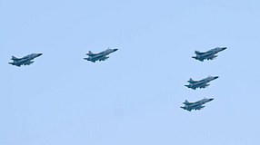 Fünft FJ-17-Kampfflugzeuge fliegen bei blauem Himmel über Baku.