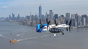 Das Foto zeigt das elektrische Lufttaxi von Joby Aviation im Flug über New York. Das eVTOL mit mehreren schwenkbaren Propellern trägt die Kennung N545JX und fliegt über dem Hudson River; im Hintergrund ist die Skyline von Manhattan mit dem One World Trade Center sichtbar. Laut Dateiname stammt die Aufnahme aus dem Jahr 2026.