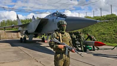 Bewaffneter Soldat vor Mikojan MiG-31 Foxhound