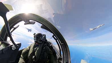 Eurofighter-Pilot im Cockpit mit zwei Mikojan MiG-31 im Hintergrund