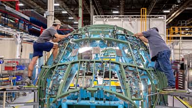 Monteure arbeiten an erster Lockheed Martin E-130J Hercules