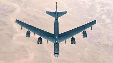 B-52H in der Luft über Wüste von oben