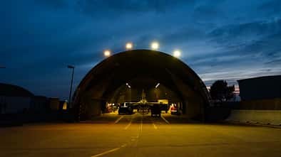 F-16 in Flugzeug-Schutzbau bei Abenddämmerung