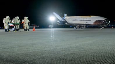 Bodenmannschaft in Schutzanzügen vor X-37B