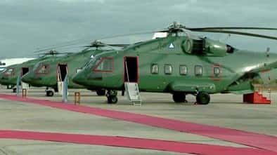 Drei russische Mi-38T stehen auf einem Flugplatz mit roten Teppichen im Vordergrund.