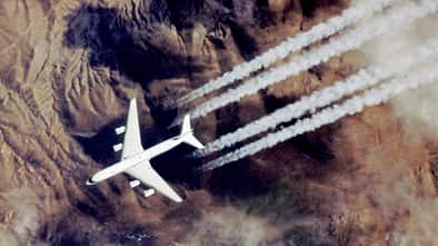 Douglas DC-8 der NASA im Flug über Gebirge mit sichtbaren Kondensstreifen