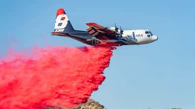 C-130-Transporter wirft rotes Löschmittel ab