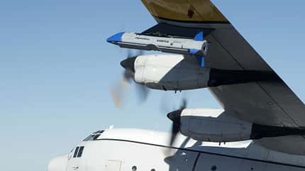 X-61A, Dynetics, DARPA, Gremlins, Dynetics X-61A Gremlins Air Vehicle unter einer C-130 Hercules.