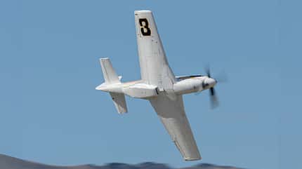 P-51D, P51D, Bardahl Special, Super Mustang, Reno Air Race, Rennflugzeug, Racer Die Bardahl Special im Kurvenflug, fotografiert von unten, vor hellblauem Himmel.