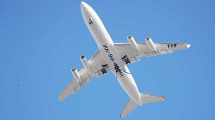 Iljushin Il-96-400M, Il-96, Vierstrahler, Passagierflugzeug, Russland, Iljushin Ein Iljuschin Il-96-400M Flugzeug, fotografiert von unten im Flug, mit ausfahrendem Fahrwerk und markanter weißen Lackierung vor klarem, blauem Himmel.