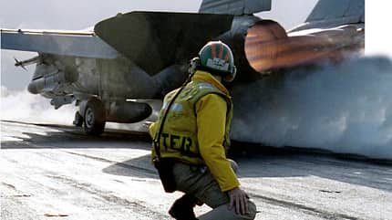 Ein Deckoffizier überwacht den Start einer F-14 Tomcat vom Flugdeck des Flugzeugträgers USS Nimitz 