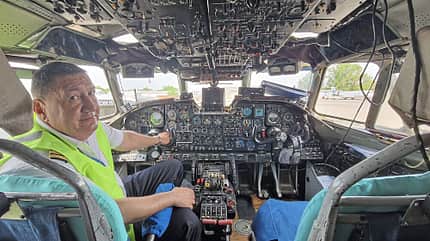 Cockpit, Pilot, Flugzeug, Instrumente, Luftfahrt, Innenraum Ein Pilot sitzt im Cockpit eines Flugzeugs und blickt zur Kamera. Zu sehen sind zahlreiche Instrumente und Bedienelemente.