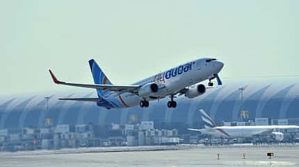 Flugzeug, Start, Flughafen, Passagierflugzeug, Luftfahrt Ein Passagierflugzeug startet auf einer Landebahn an einem Flughafen, im Hintergrund ist ein weiteres Flugzeug und ein Terminalgebäude zu sehen.