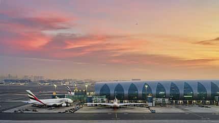 Flughafen, Emirates, Flugzeug, Terminal, Sonnenuntergang, Luftfahrt Flughafen mit geparkten Emirates-Flugzeugen vor einem modernen Terminalgebäude bei Sonnenuntergang.