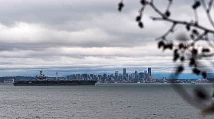 USS Nimitz Flugzeugträger vor Stadtkulisse