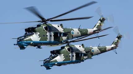 Mil Mi-24, Kampfhubschrauber, Äthiopien, Mil Mi-24 Hind, Heeresflieger, Tarnanstrich, Doppelrotor, Luftfahrt, Militärhubschrauber, Formationsflug Zwei äthiopische Kampfhubschrauber vom Typ Mil Mi-24 im Flug, Tarnanstrich, Landeswappen sichtbar.
