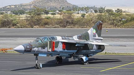 MiG-23, Äthiopien, Kampfflugzeug, Militärjet, Luftwaffe, Düsenjäger, Flugplatz, Tarnanstrich, Schwenkflügler, Sowjetisches Flugzeug Äthiopische MiG-23 auf einem Flugplatz, Seitenansicht, mit Tarnanstrich und sichtbarer Kennung 1202.