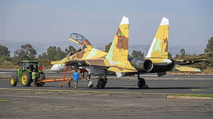 Su-30, Äthiopien, Kampfflugzeug, Militärjet, Doppelleitwerk, Tarnlackierung, Bodenpersonal, Flugplatz, Traktor, Luftstreitkräfte Äthiopische Su-30 auf Flugplatz, Bodenpersonal und Traktor bei Bodenarbeiten, offene Cockpithaube, Tarnlackierung.