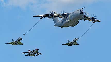 Airbus A400M, Luftbetankung, Militärtransporter, Kampfflugzeug, Mehrzweckflugzeug, Turboprop, Luftwaffe, Antidotum 2026, Luftfahrt, Tarnkappenjet Ein Airbus A400M Militärtransporter beim Luftbetanken von drei Kampfflugzeugen im Flug.