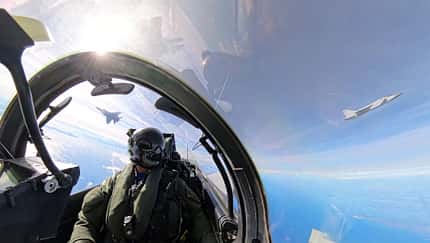 Eurofighter-Pilot im Cockpit mit zwei Mikojan MiG-31 im Hintergrund