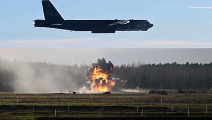 Boeing B-52H Stratofortress beim Bombenabwurf mit Explosion am Boden (Montage)