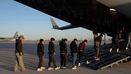 Gefesselte Menschen betreten C-17 der USAF 