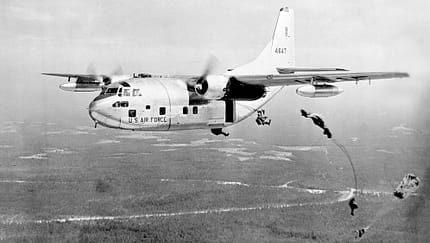 Fallschirmspringer springen aus der C-123B