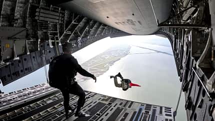 Rettungsschwimmer springen aus C-17-Transporter