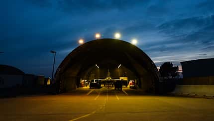 F-16 in Flugzeug-Schutzbau bei Abenddämmerung