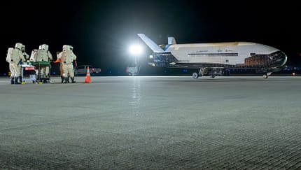 Bodenmannschaft in Schutzanzügen vor X-37B
