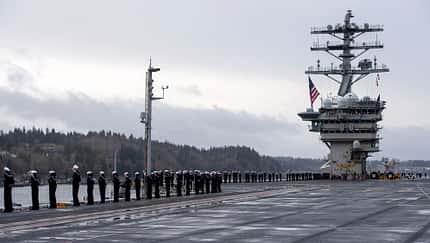 Seeleute umringen das Deck der USS Nimitz beim Auslaufen