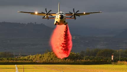 Leonardo C-27J beim Abwurf von Löschmittel von vorne