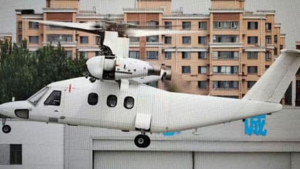 Kipprotor-Flugzeug aus China in der Luft vor Häuserkulisse