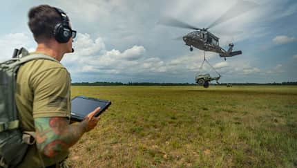 Black Hawk, Lockheed Martin, Northern Strike, Matrix Ein Soldat, links im Bild, steuert einen Black-Hawk-Hubschrauber autonom über einem Feld.