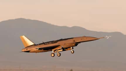 Unbemanntes Kampfflugzeug in der Luft mit ausgefahrenem Fahrwerk