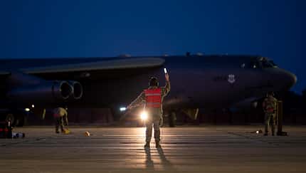 Einweiser gibt Signale an Bomber beim Rollen nachts