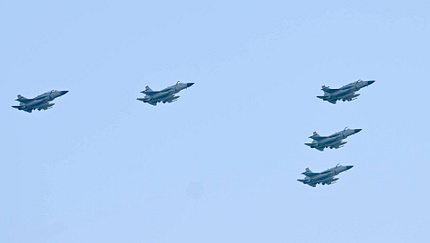 Fünft FJ-17-Kampfflugzeuge fliegen bei blauem Himmel über Baku.