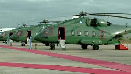 Drei russische Mi-38T stehen auf einem Flugplatz mit roten Teppichen im Vordergrund.