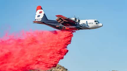 Coulson Aviation, Wasserbomber, Lockheed, C-130, Hercules, Löschflugzeug C-130-Transporter wirft rotes Löschmittel ab
