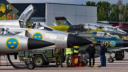 Pilot im Cockpit der Saab Viggen mit weiteren Jets im Hintergrund