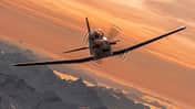 Pilatus PC-7 MKX Demonstrator im Flug vor den Alpen bei Sonnenuntergang